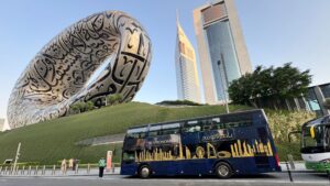 A luxurious dining setup inside the Bustronomy Dubai bus with panoramic views of the city skyline.